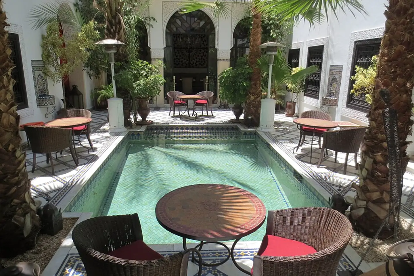 Riad courtyard with tables and fruit trees in Marrakesh